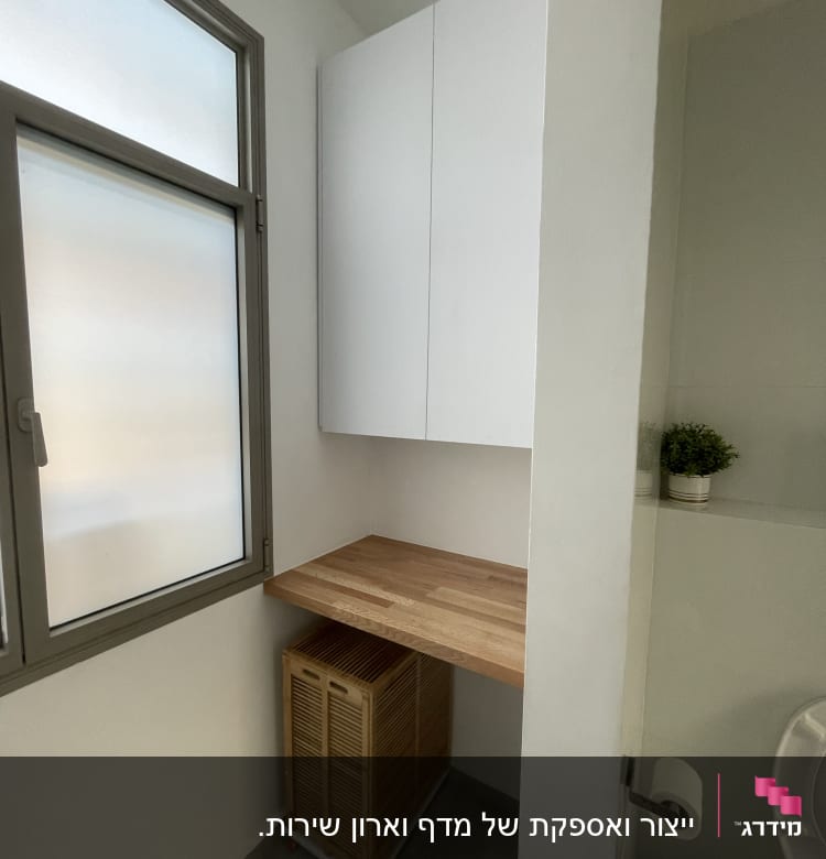 משטח עץ מותקן על קיר ליד ארון לבן